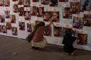 A woman touches photos of Israelis missing and held captive in Gaza (Petros Giannakouris/AP)