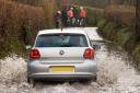 A car makes it way through flood water in Garnswllt near Ammanford