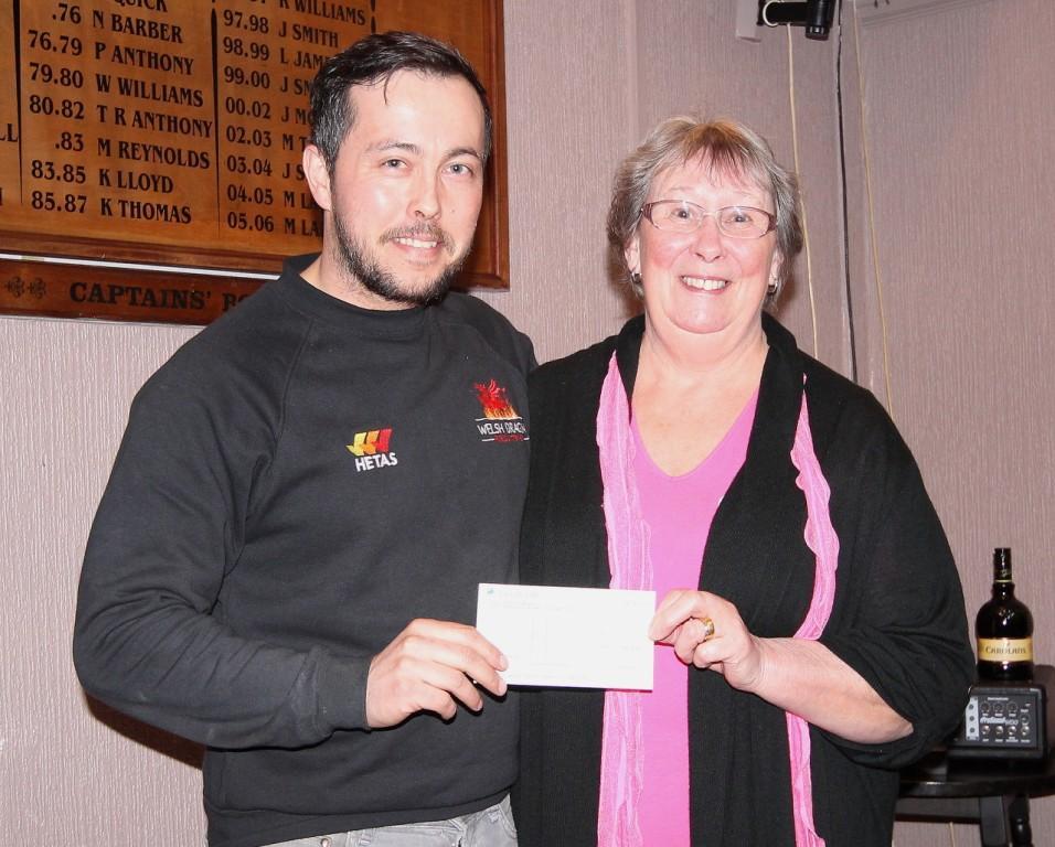 Chris Davies receives a cheque from Mary Anderson for his sponsored walk to Penyfan for a family who recently lost their six-year-old daughter. Pic: SDD