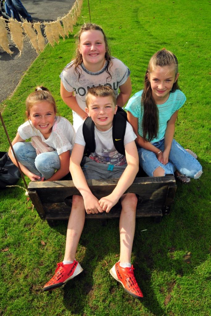 Bro Banw school mates Alexa Woodley (10), Charlie Howatson (10), Talia Woodley (11) and Sophie Baker (10) take turns in the stocks.  Picture by Mark Davies