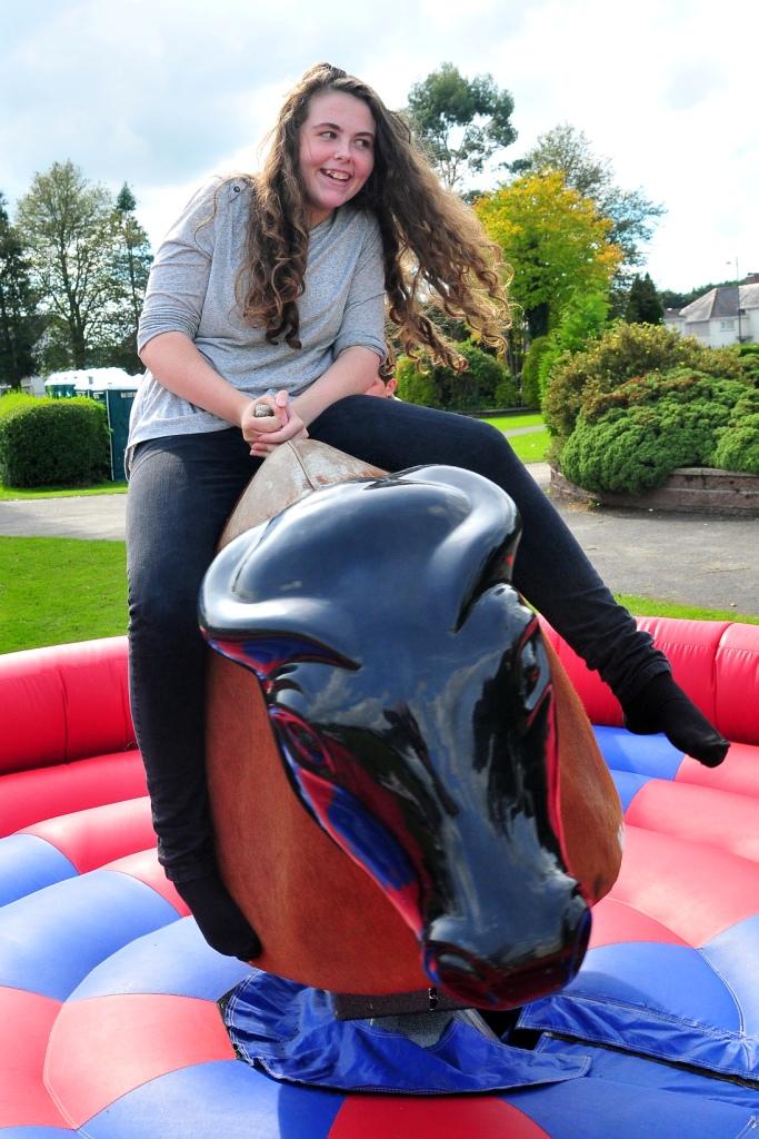 Amman Valley pupil Sian Thomas tests her skill on the Bucking Bronco.  Picture by Mark Davies