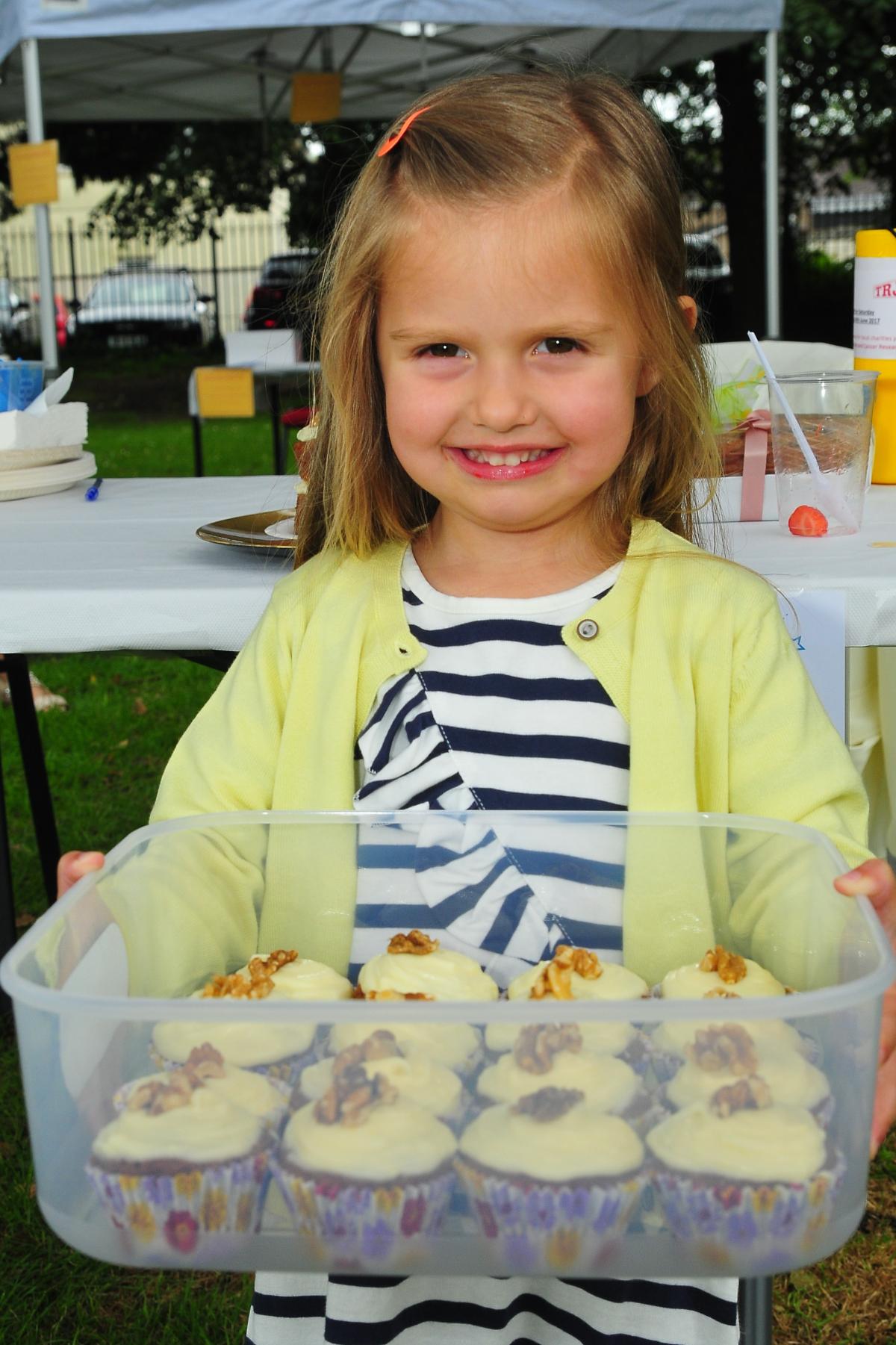 Three year old Lucy Lydiate helps out on the cake stall.