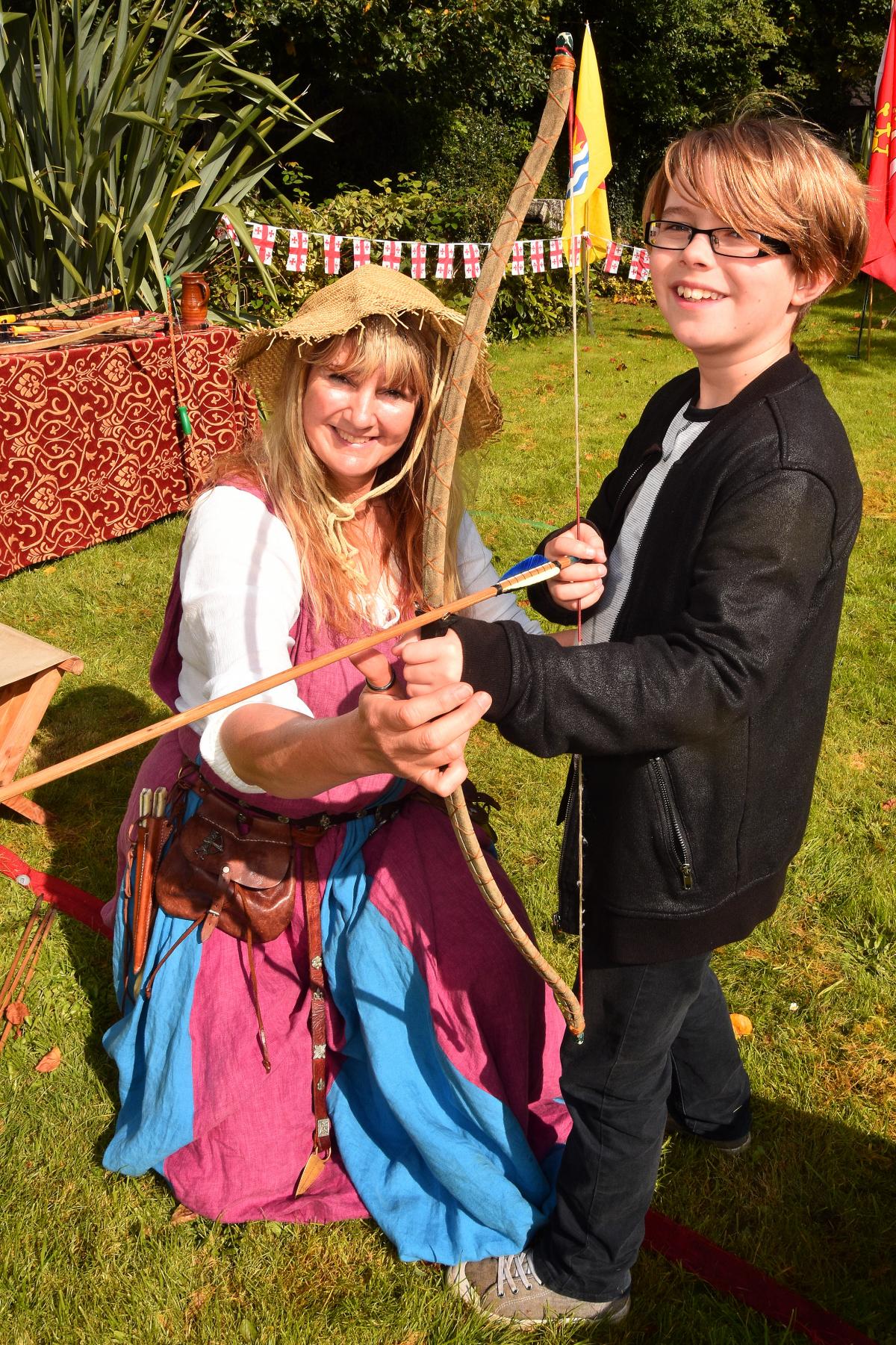 Nine year old Nathaniel gets longbow instruction with Pam Eddiford from the Bowlore medieval display group.  Pic Mark Davies