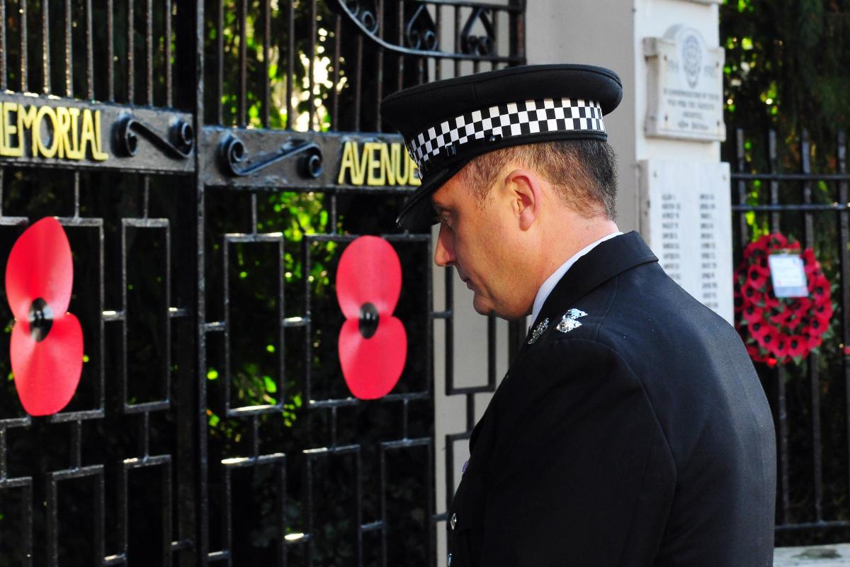 A police officer lays a wreath at the Memorial Gates.