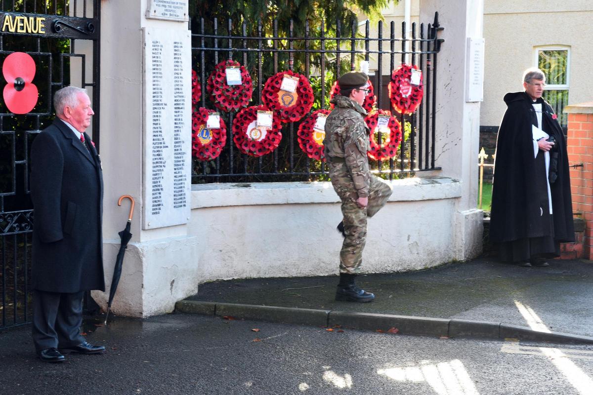 An army cadet places a wreath at Ammanford Memorial Gates.