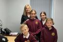 Some of Llandybie Primary School's pupils at the Ammanford Ashmole & Co office with Laura Craddock