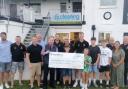 The cricket club receiving the cheque for £1,000
