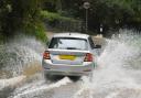 A car making its way through floodwater on the road near Garnswllt, Ammanford. Picture: Stuart Ladd