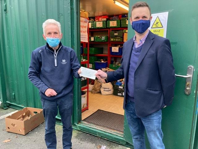 Councillor Llewellyn presents a cheque to Meidrim Thomas of Ammanford Foodbank