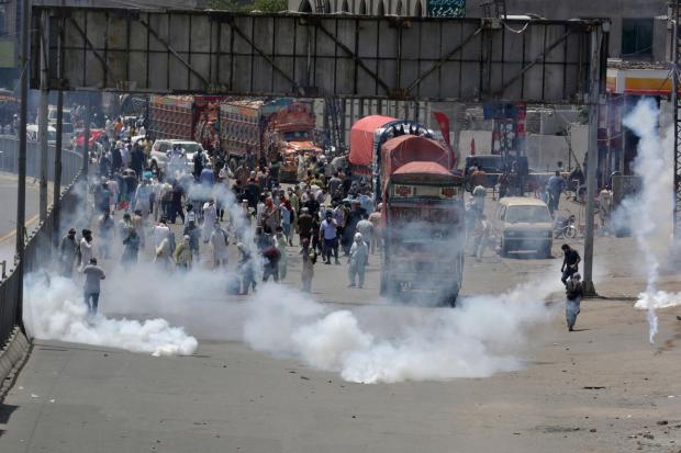 Police fire tear gas to disperse supporters of Pakistan’s key opposition party marching towards Islamabad