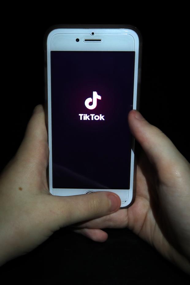 South Wales Guardian: A person with TikTok open on their phone. Credit: PA