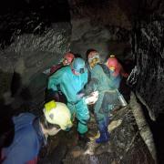 Handout photo taken with permission from the Facebook page of the South & Mid Wales Cave Rescue Team of members of a rescue team carrying an injured caver on a stretcher through a cave. (PA)
