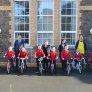 Tycroes children stand proudly with their new bikes.