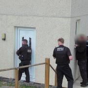 The officers, with the wanted man's dad, outside his house. Picture: BBC