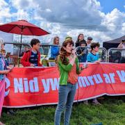 Catrin O'Neill talking to the crowd at Cymdeithas yr Iaith's rally at the Eisteddfod in Tregaron (Image: Twitter/Cymdeithas yr Iaith).
