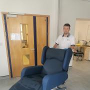 Physiotherapist Scott Jakeman with the new chair. Picture: Hywel Dda Health Charities.