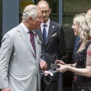 Mari Thomas giving then-Prince Charles a pair of cufflinks.