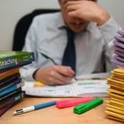 File photo dated 05/03/17 of a teacher next to a pile of classroom books. Pic: PA Wire.